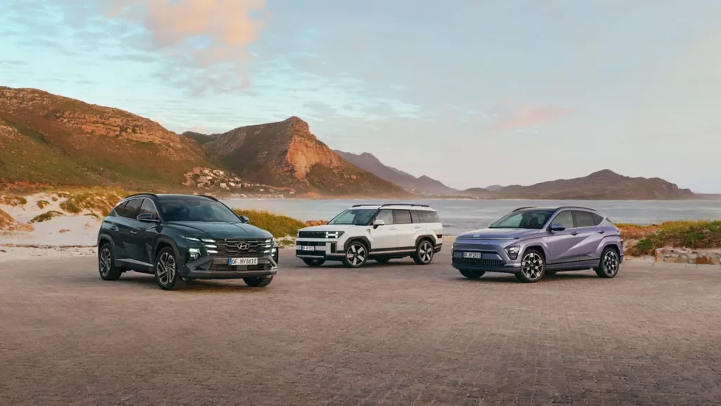 Hyundai TUCSON, SANTA FE och KONA uppställda vid en kustväg i kvällsljus