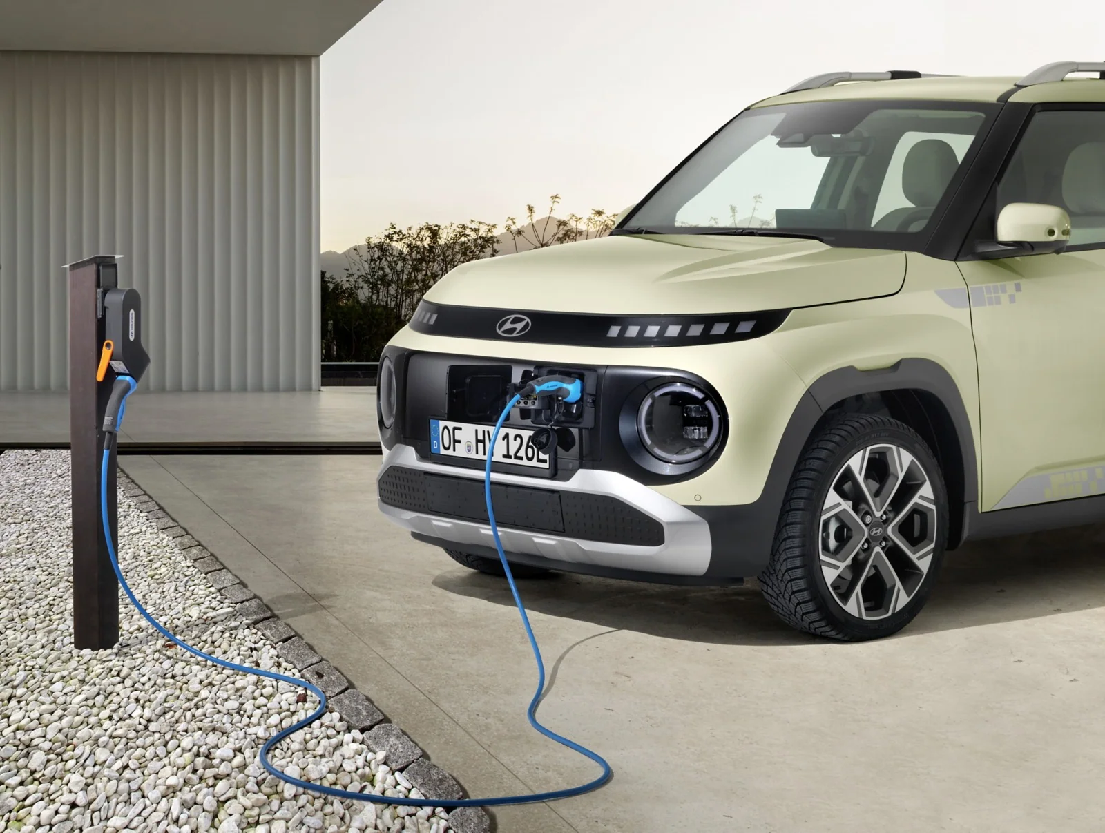 Hyundai INSTER ansluten till en laddstation vid ett hus