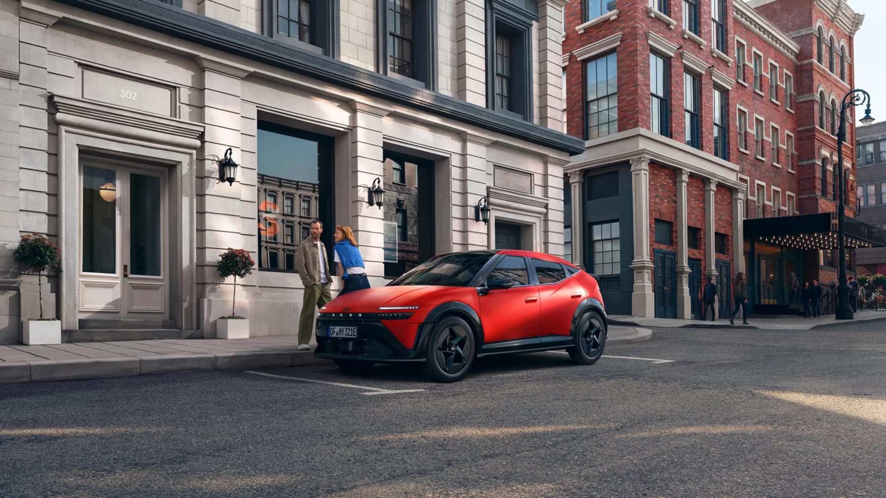 Hyundai IONIQ 3 i profil, en kvinna går förbi på trottoaren