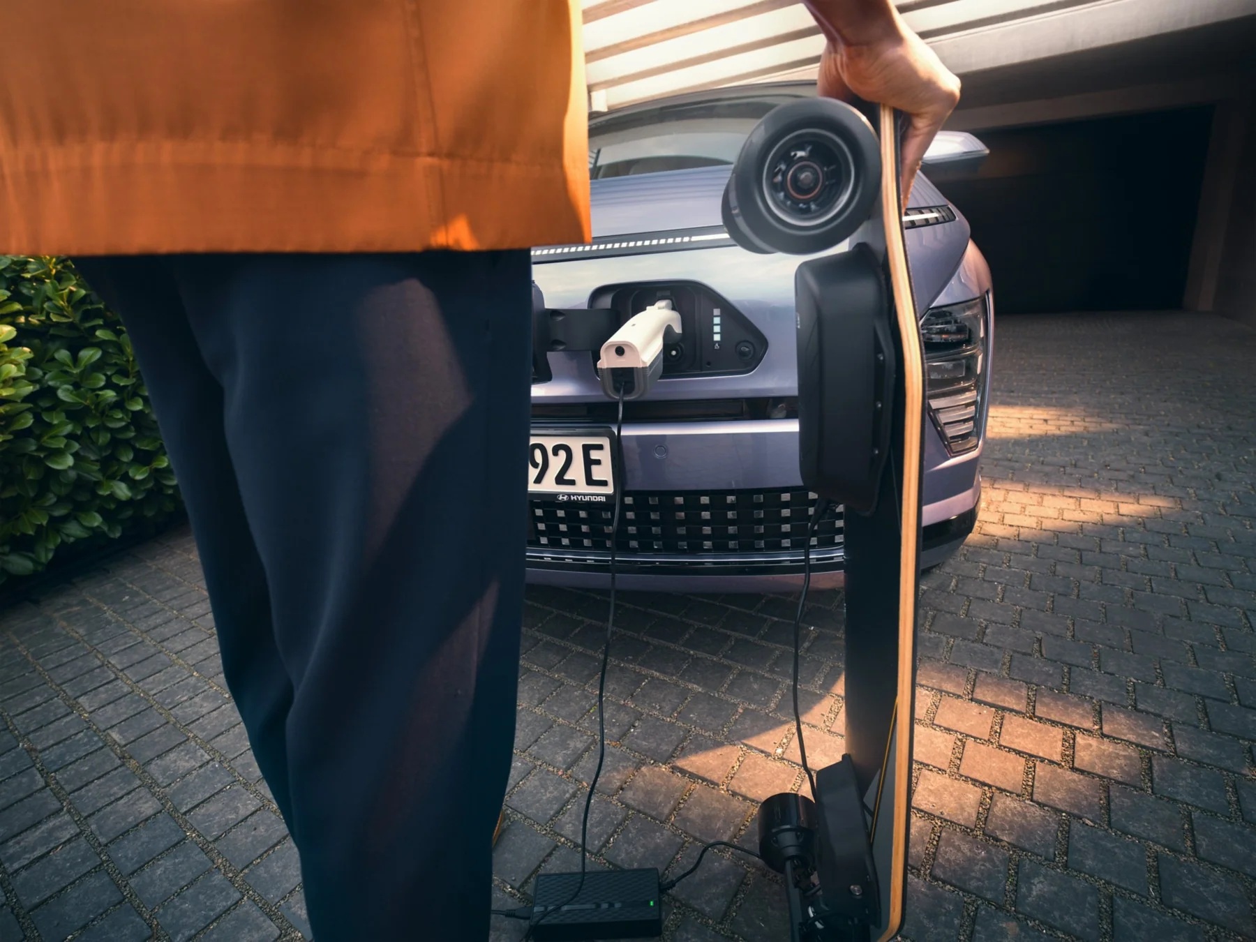 En elektrisk longboard laddas från Hyundai KONA Electrics laddport