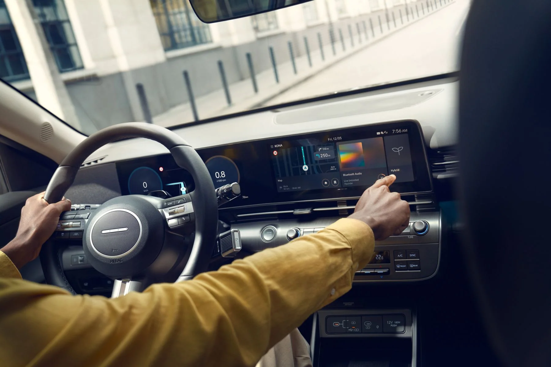 Föraren rör vid pekskärmen i Hyundai KONA Hybrid under körning