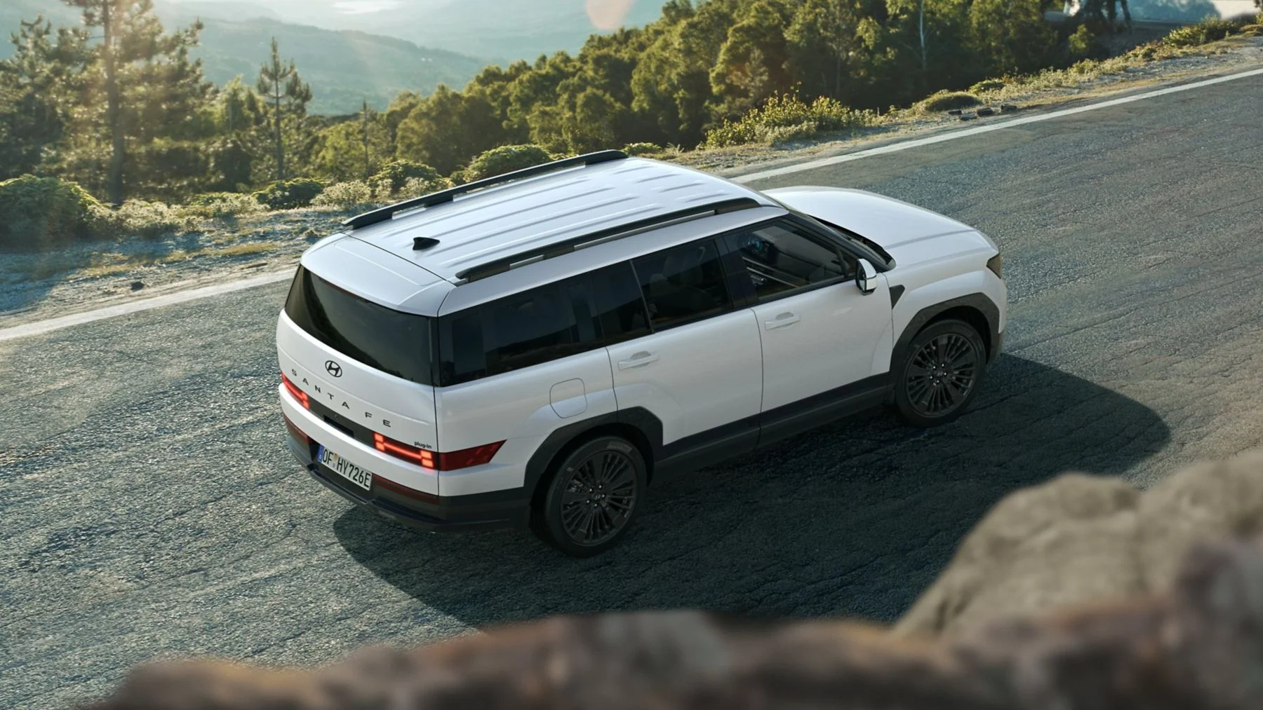 Hyundai SANTA FE Plug-in Hybrid i rörelse på en slingrande bergsväg