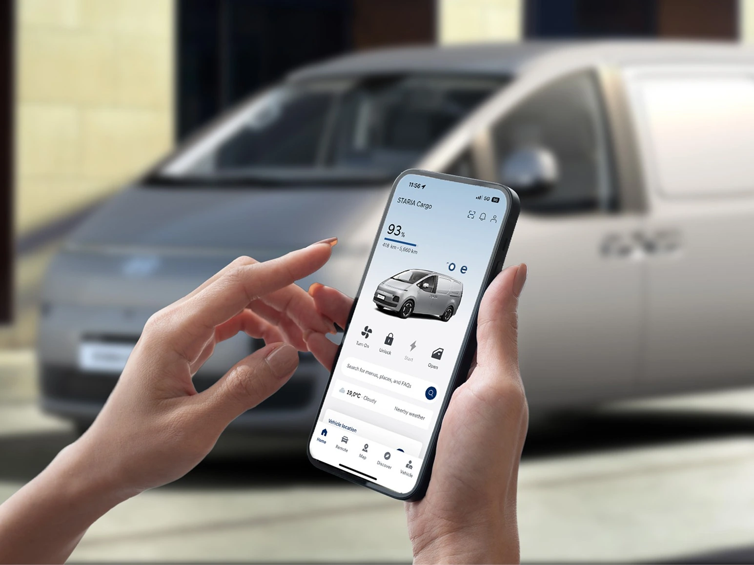 myHyundai-appen på en mobiltelefon framför en Hyundai STARIA Cargo