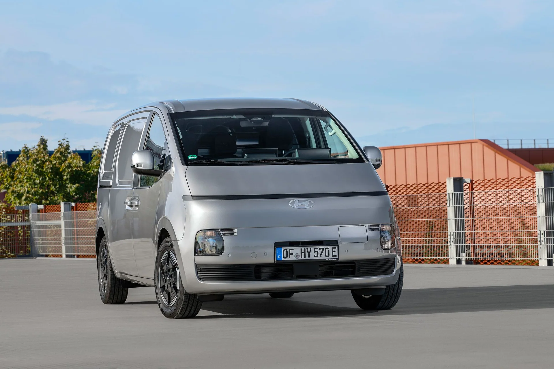 Silvergrå Hyundai STARIA Cargo snett framifrån med den slutna grillen och ljusbandet