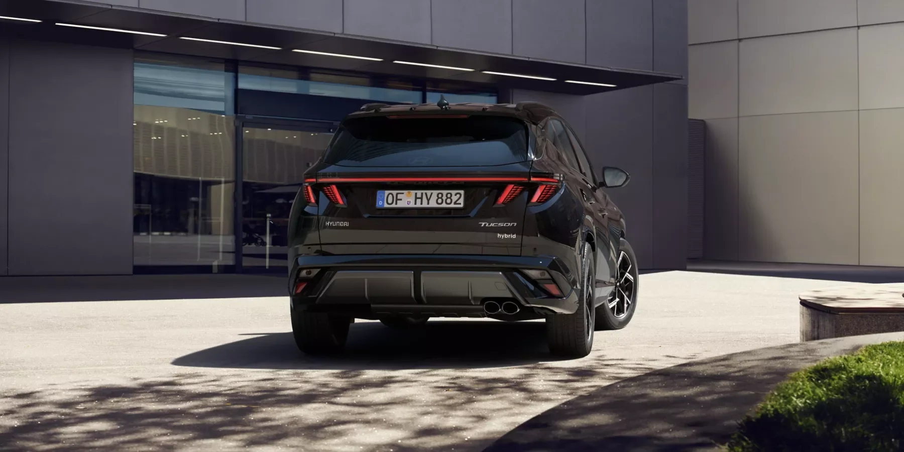 Hyundai TUCSON Hybrid N Line parkerad framför en modern byggnad